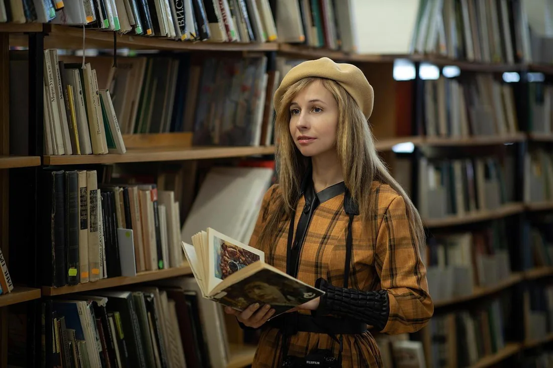 An author browsing a bookshelf